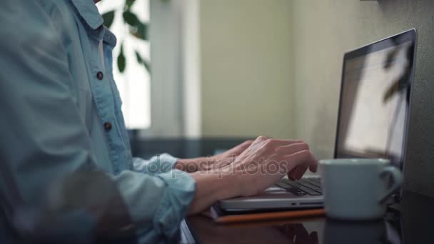 Casual vestido jovem usando laptop fazendo anotações no bloco de notas em casa — Vídeo de Stock