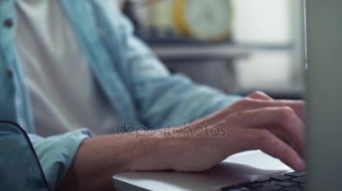 Erkek el mutfak dizüstü kullanarak kapatın. Genç adam evde çalışma.