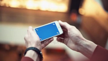 Erkek silah ile alışveriş merkezi mavi perde smartphone kullanarak