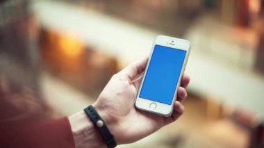 Erkek silah ile alışveriş merkezi mavi perde telefon kullanma