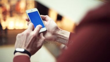 Erkek silah ile alışveriş merkezi renk perde smartphone kullanarak
