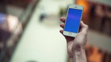 Adam silah alışveriş merkezi mavi ekran smartphone kullanarak