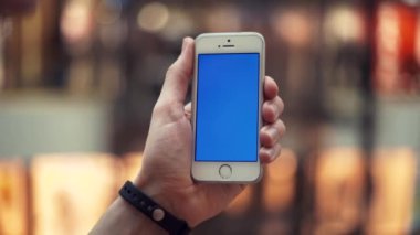 Erkek silah alışveriş merkezi asansörlü mavi ekran smartphone kullanarak