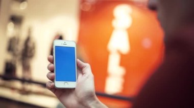 Erkek silah ile alışveriş merkezi mavi perde telefon kullanma