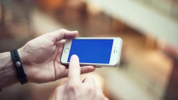 Braços masculinos usando telefone com tela azul no shopping — Vídeo de Stock