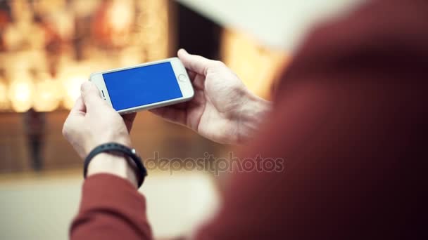 Мужские руки с помощью смартфона с хромированным экраном в торговом центре — стоковое видео