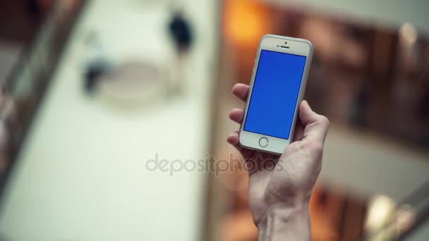 Braccia maschili con smartphone con display blu nel centro commerciale — Video Stock