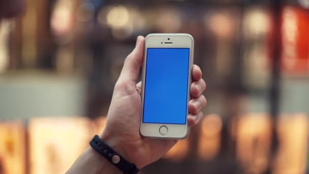 Мужские руки с помощью смартфона с синим дисплеем в торговом центре с лифтами — стоковое видео