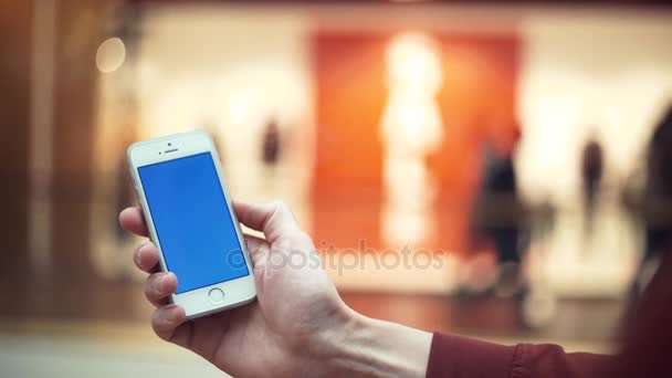 Braccia maschili con telefono con schermo blu nel centro commerciale, poster di vendita — Video Stock