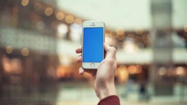 Erkek el ile alışveriş merkezinde renk perde smartphone kullanarak