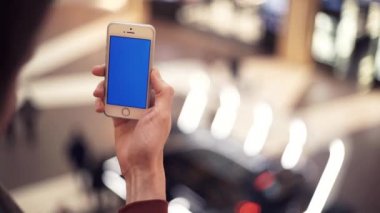 Erkek silah ile alışveriş merkezinde renk perde smartphone kullanarak