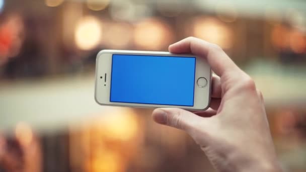 Braços masculinos usando telefone com tela azul no shopping center — Vídeo de Stock