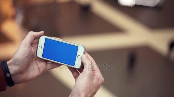 Male arms using telephone with blue screen in shopping center — Stock Video