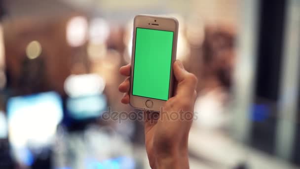 Man wapens smartphone met groen scherm in winkelcentrum — Stockvideo