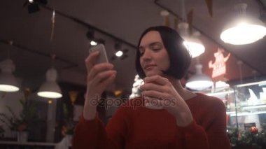 Kafede oturan selfie alarak smartphone kullanan çekici kadın. Noel zamanı