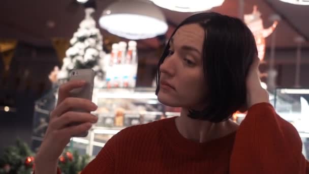 Selfie kafede alarak smartphone kullanarak gülümseyen genç neşeli kadının yakın çekim — Stok video