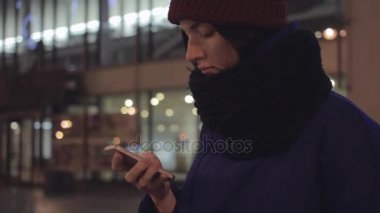 Akıllı telefon kullanan çekici genç kız portresi. Festival Bina aydınlatma