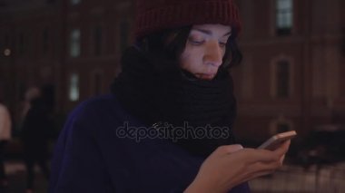 Genç kız ceket giymiş ve smartphone kullanarak atkı örgü yakın çekim