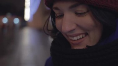 Genç kız ceket giymiş ve eşarp kullanarak gülümseyen örme smartphone