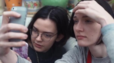 Kaç kız evde kanepede yatan smartphone cep telefonu ile selfie alarak yakın çekim.