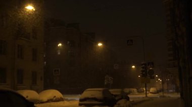 Yoğun kar yağışı gece şehir içinde. Lamba yolda düşen kar taneleri aydınlatmak