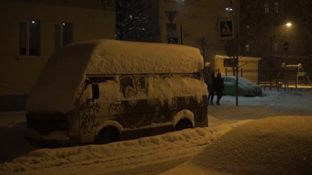 Фургон покрыт снегом. Сильный снегопад в городе ночью . — стоковое видео