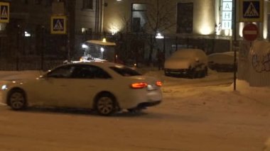 İnsanlar ve cadde boyunca geceleri ağır kar kış aylarında taşıma arabaları.