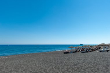 Siyah Kamari beach Santorini, Yunanistan üzerinde güneşlenme insanlar.