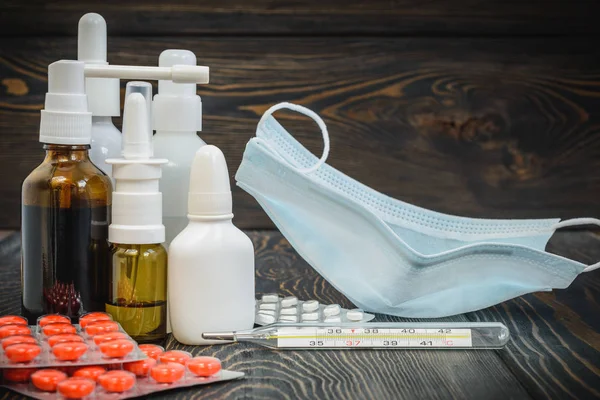 Hap, burun soğuk tedavisi, grip akan bir termometre ile masada bırakır.