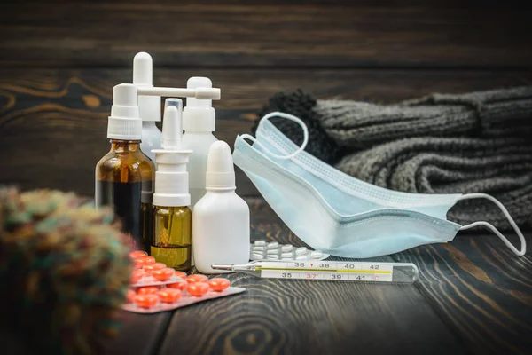 Hap, burun soğuk tedavisi, grip akan bir termometre ile masada bırakır.