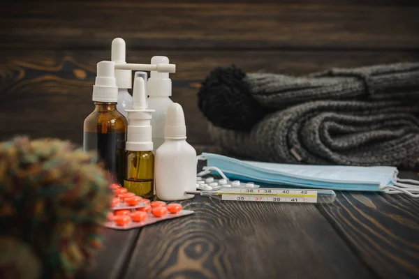 Hastalık ve yün, İpek eşarp kap bir rustik ahşap zemin üzerine grip ilaç tablet. termometre yüksek ısı 39.1 sezon başına