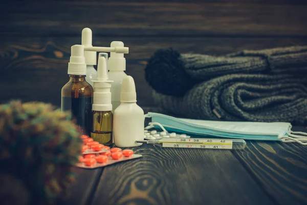 Hastalık ve yün, İpek eşarp kap bir rustik ahşap zemin üzerine grip ilaç tablet. termometre yüksek ısı 39.1 sezon başına