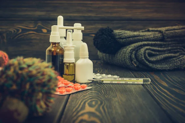 Hastalık ve yün, İpek eşarp kap bir rustik ahşap zemin üzerine grip ilaç tablet. termometre yüksek ısı 39.1 sezon başına