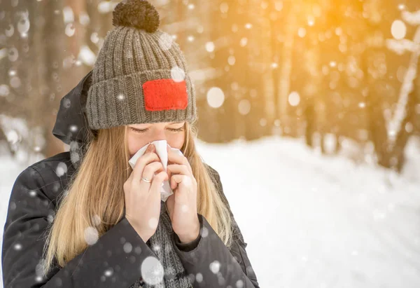 Žena v lesích sněžení šátek kýchání a použití tkání, portrét — Stock fotografie