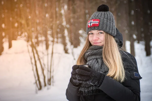 Mooie gelukkig lachende vrouw met een kopje van de winter op de straat. glimlach van genot meisje buiten warme drank — Stockfoto