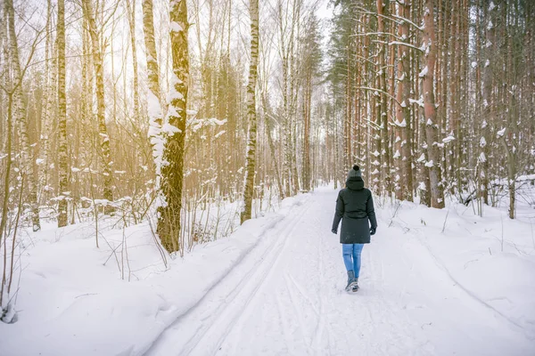 Chica caminando en el camino en invierno bosque ruso — Foto de Stock