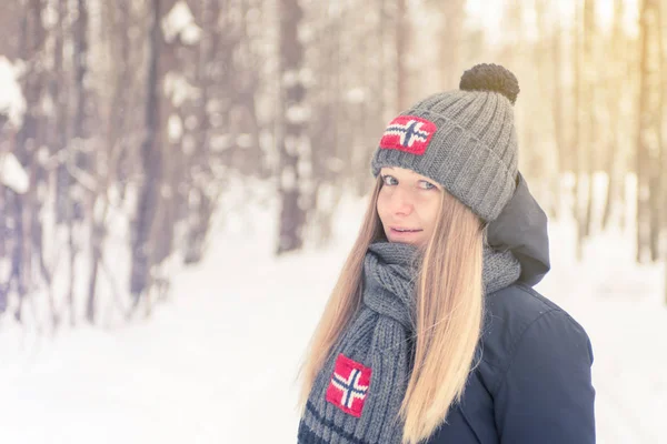 La joven en el invierno de madera fría en una gorra y bufanda con —  Fotos de Stock