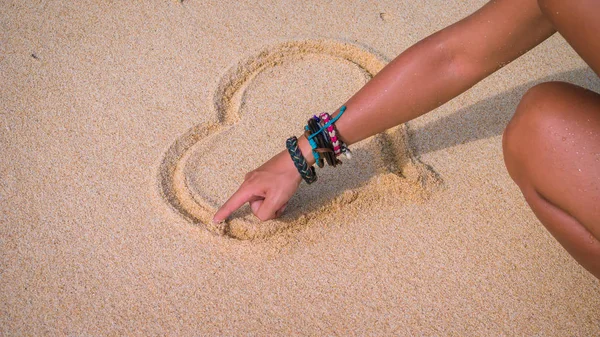 El çizmek deniz kalp yakınındaki kum üzerinde