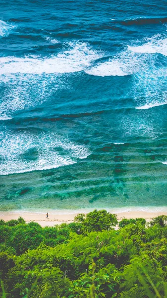 Man walking along of Nunggalan Beach. Big waves rolling on. Uluwatu, Bali, Indonesia — Stock Photo, Image