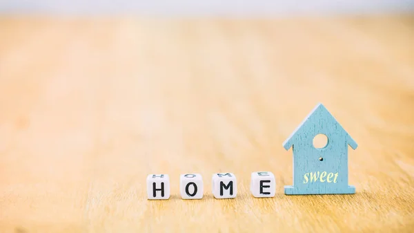 Hem söta vågräta ord kub bokstäver bakom blå huset symbol på träytan — Stockfoto