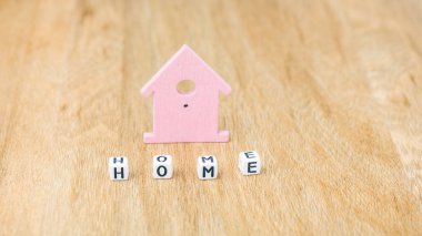 Küp harfler leylak renkli ev sembolü önünde ev kelime ahşap yüzey üzerinde