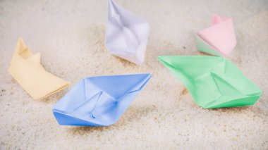 Renkli kağıt gemiler Sandy çöl üzerinde döşeme kaotik