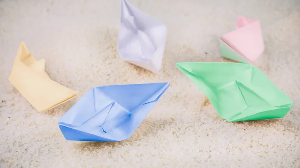 Naves de papel de colores caóticas que yacen sobre arena en el desierto — Foto de Stock