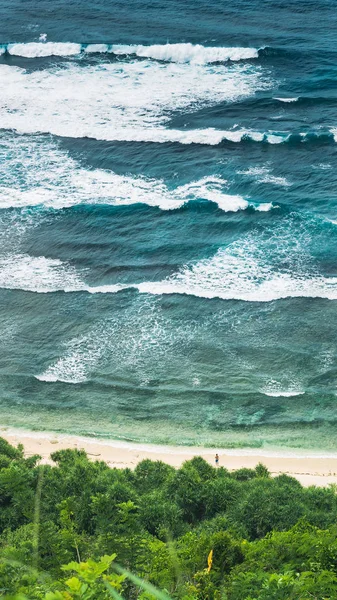 Wellen-Kaskade und Mann schaut in Element am Nunggalan Strand. uluwatu, bali, indonesien — Stockfoto