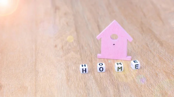 Hem ord kub bokstäver framför lila färgade hus symbol på träytan — Stockfoto