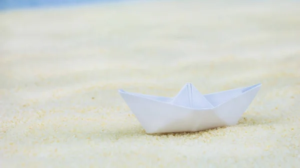 Un papel blanco borroso navega sobre arena — Foto de Stock