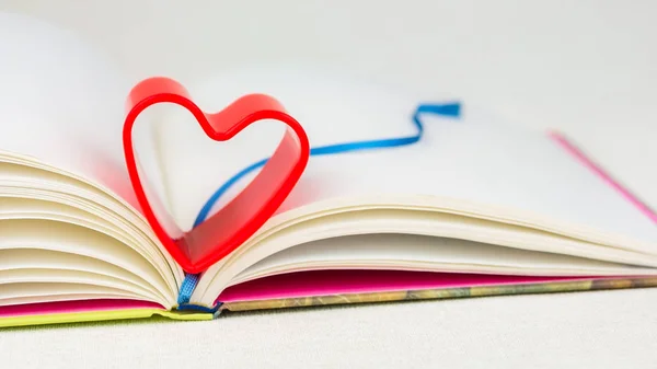 stock image Red heart over diary book with bookmark on white table