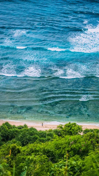 Man walking along of Nunggalan Beach. Big waves rolling on. Uluwatu, Bali, Indonesia — Stock Photo, Image