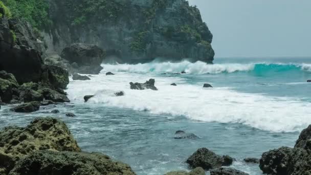 Ondas oceánicas golpeando la costa de Tembeling en la isla de Nusa Penida, Bali Indonesia — Vídeos de Stock