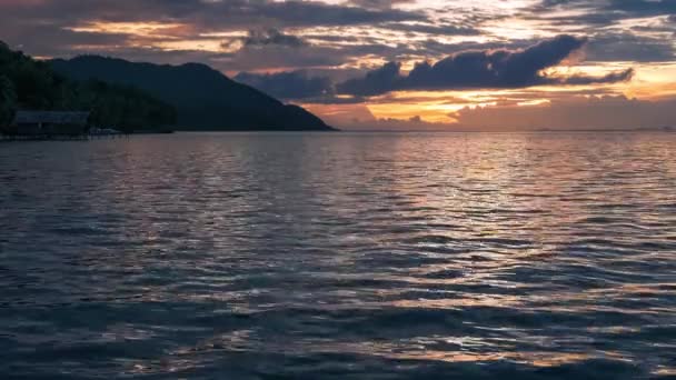 Solnedgång över Kri och Monsuar, lugna vågor flyttar på havsytan, västra Papua, Raja Ampat, Indonesien — Stockvideo